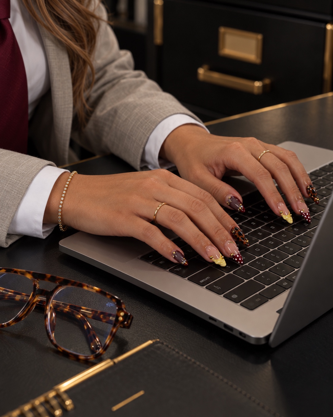 Jenica typing on a MacBook at her desk