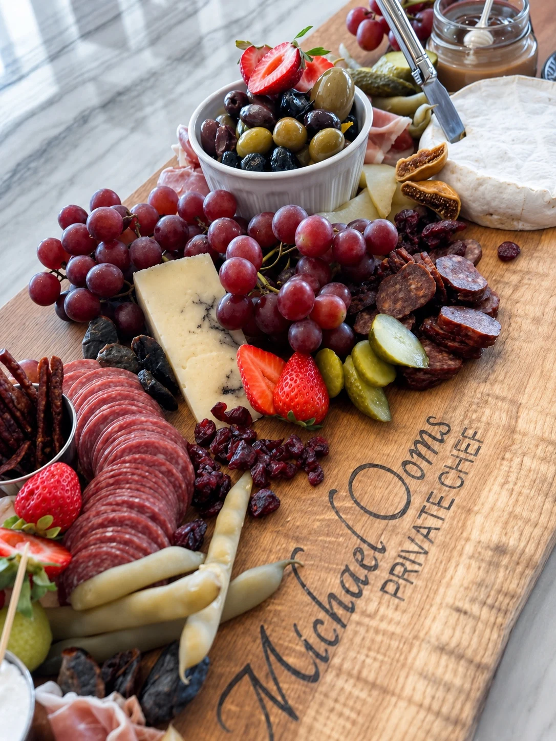 A private-chef grazing board with cheeses, fruit, olives, and charcuterie