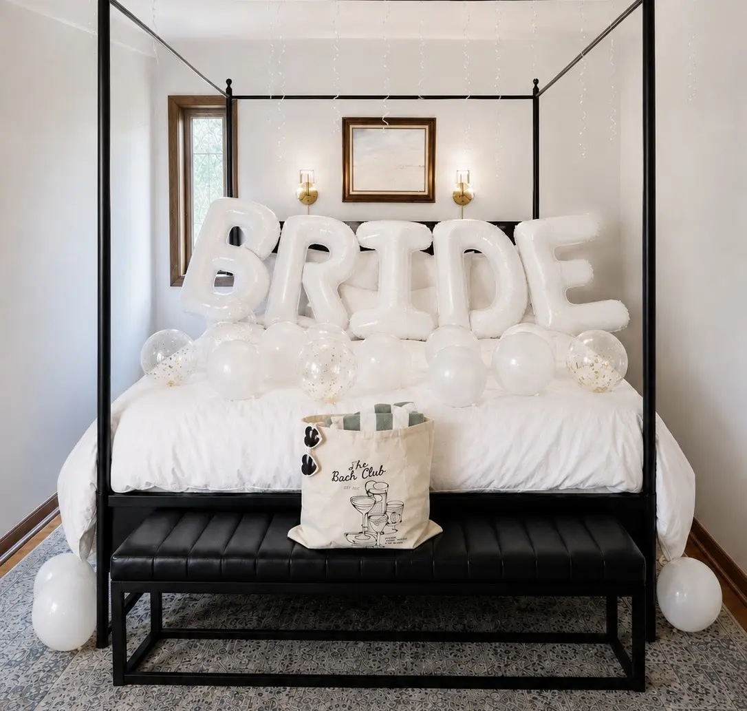 Bride bedroom arrival setup with white balloons and a Bach Club welcome bag