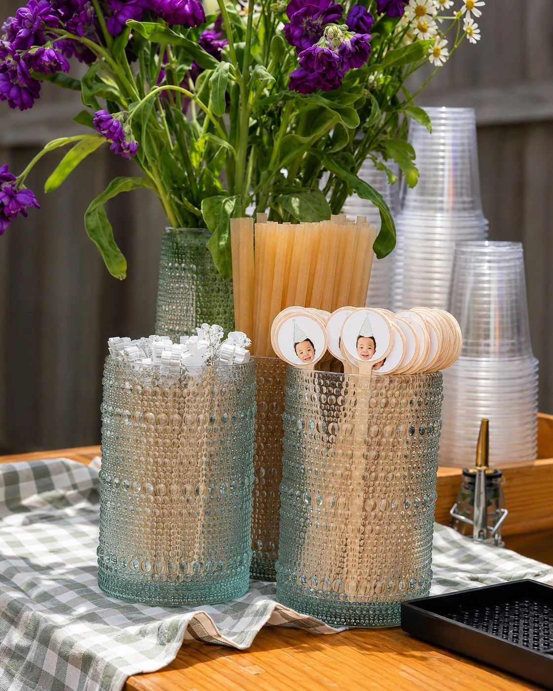 Drink station styling with purple flowers, straws, and custom drink stirrers