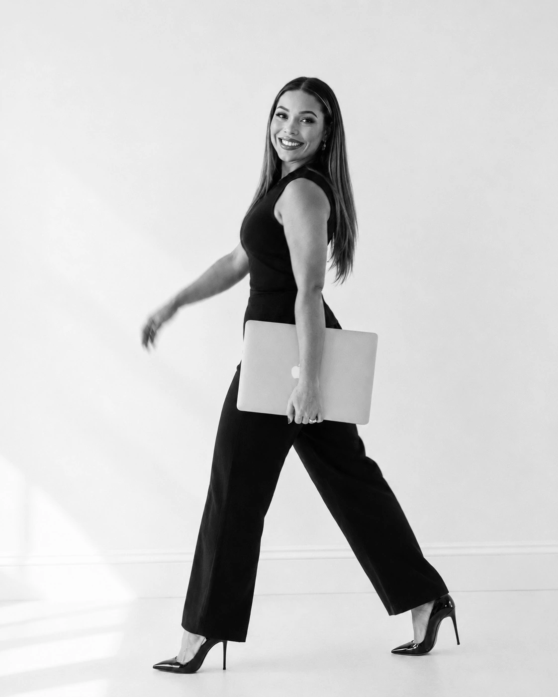 Jenica walking with her laptop in a candid editorial frame