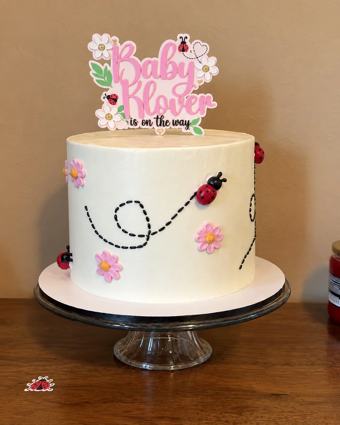 Custom white ladybug baby shower cake with pink flowers