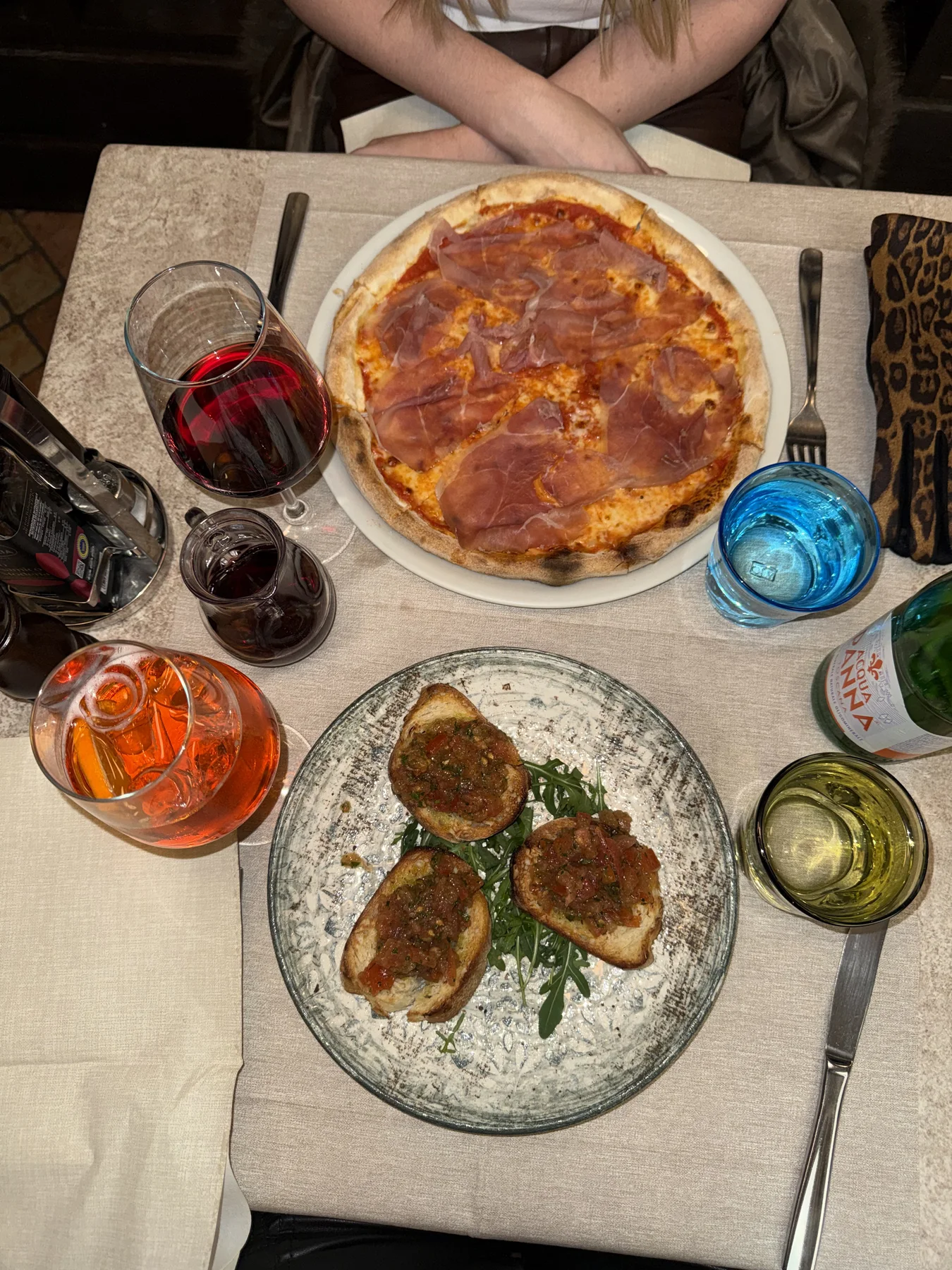 A local Venice table with pizza, bruschetta, and spritzes from above