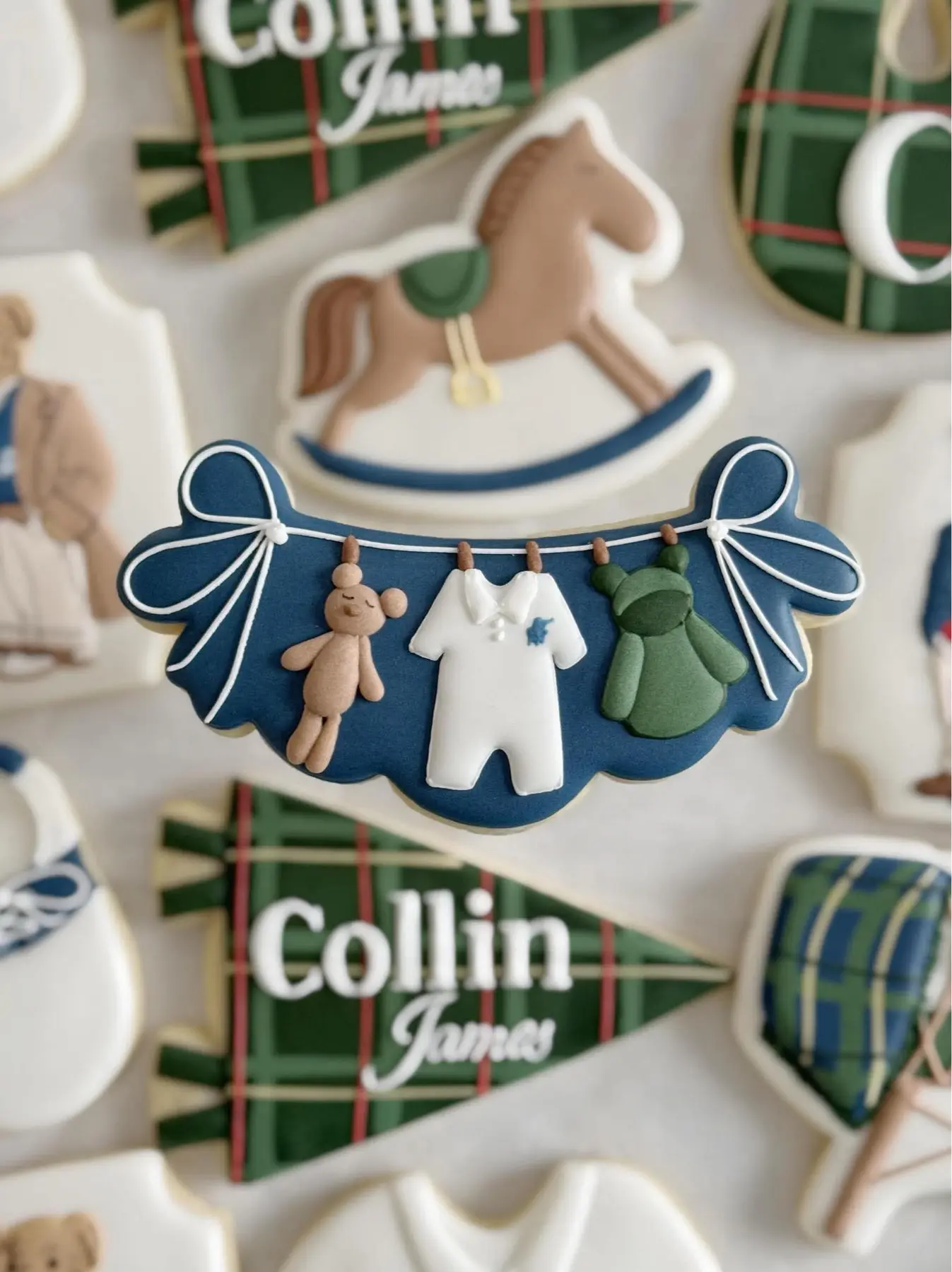 Close-up of a teddy-bear clothesline cookie with blue bows and baby clothing