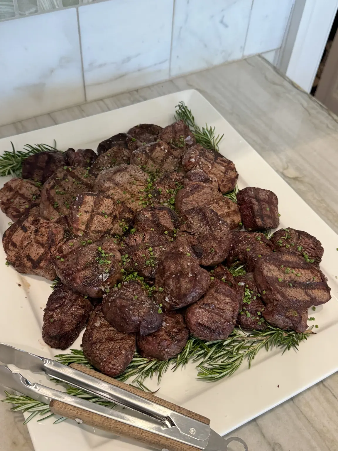 A platter of grilled steaks finished with rosemary